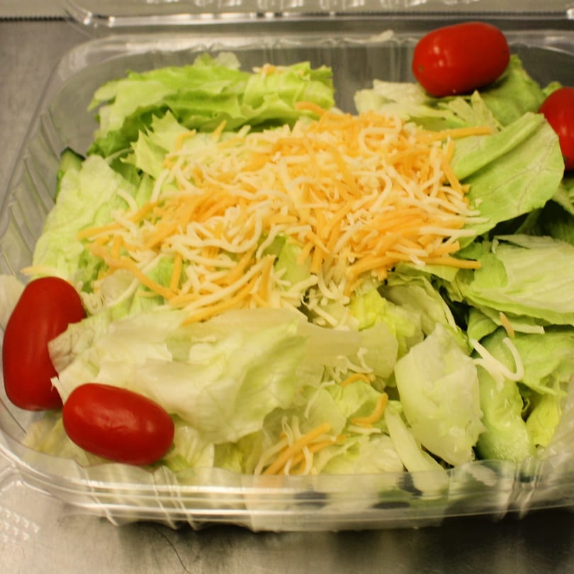 Fresh side salad with crisp lettuce, shredded cheddar cheese, and bright red grape tomatoes in a clear container.